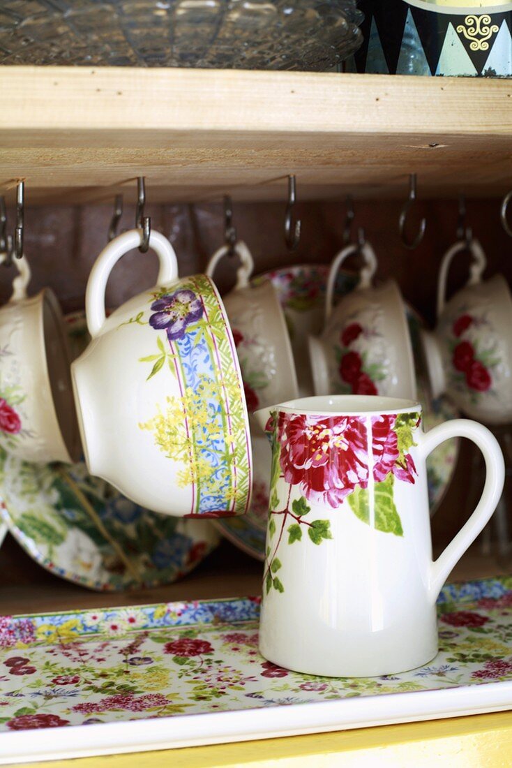 Cups and a jug on a shelf