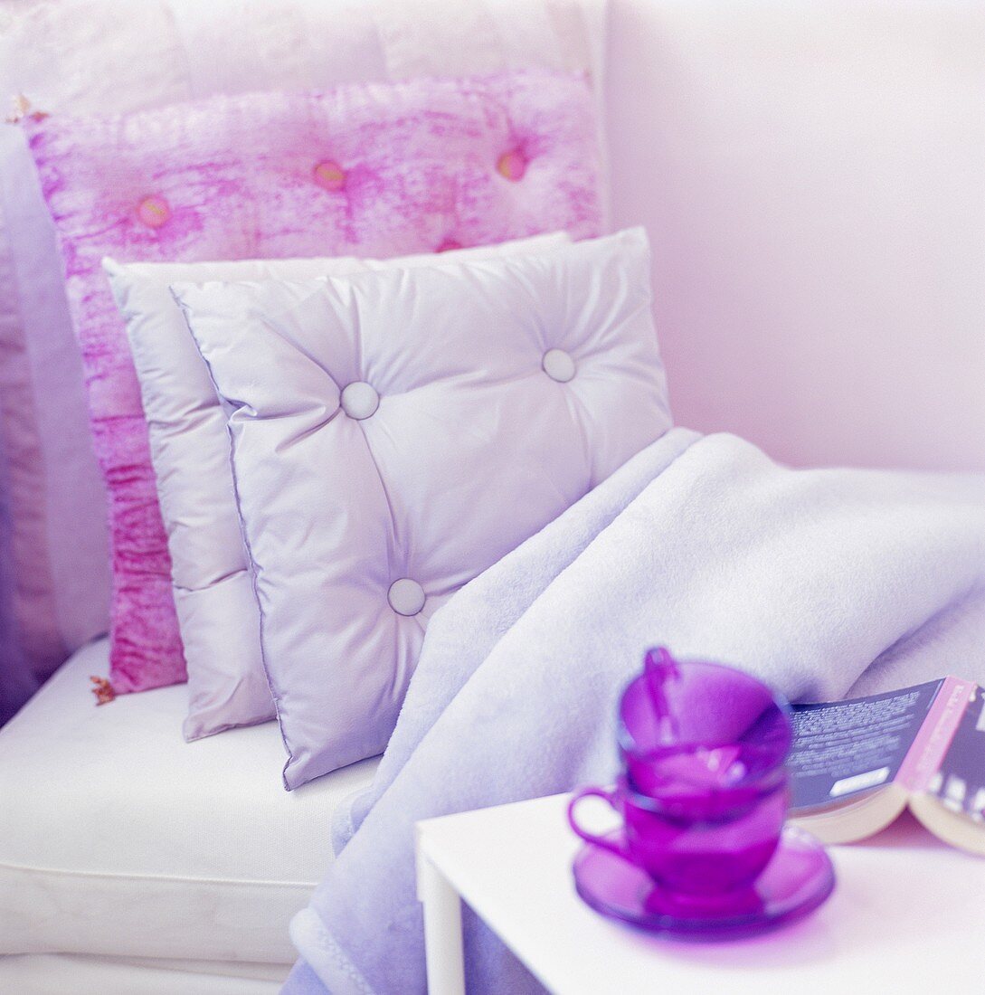 Bett mit Kissen und Decke & Beistelltisch mit Tassen und Buch