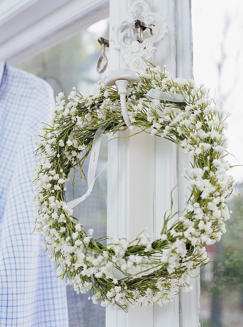 Wreath of white flowers by window
