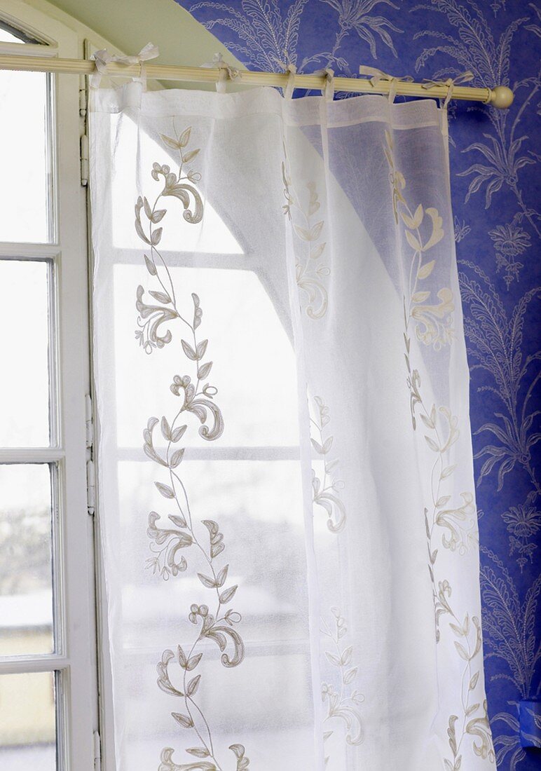 Embroidered net curtain at a window