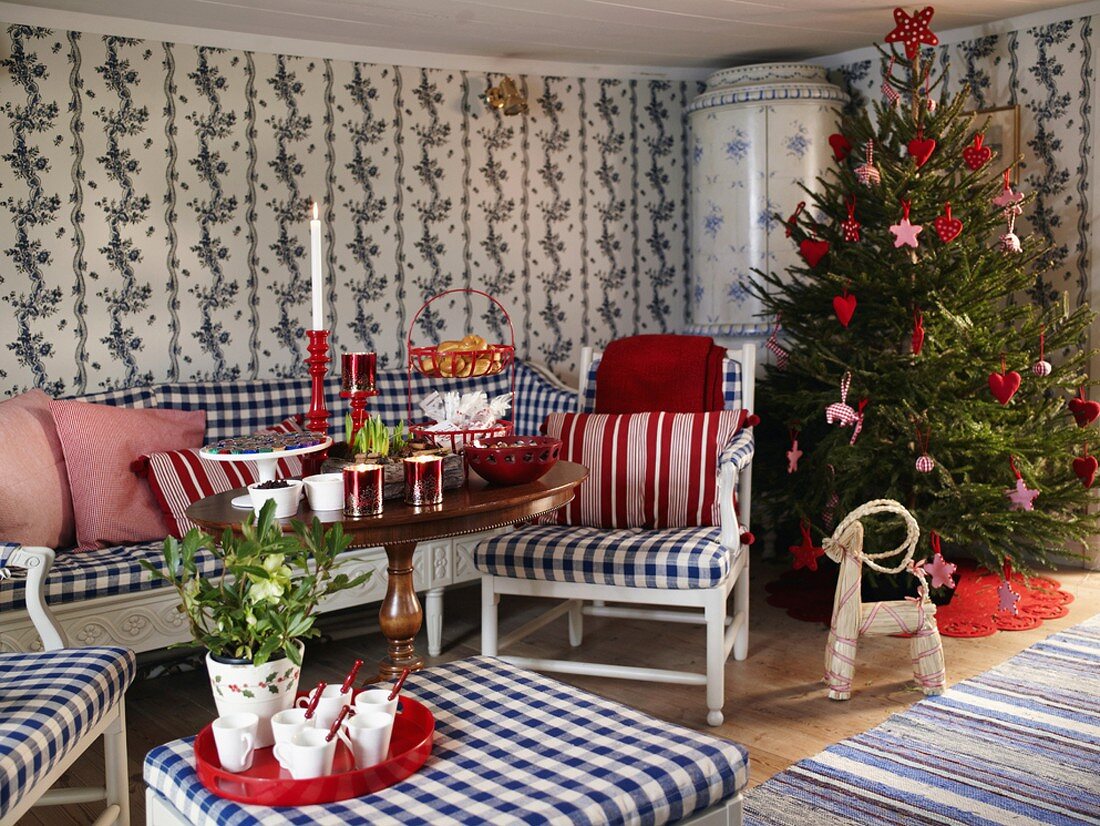 Weihnachtliches Wohnzimmer im skandinavischen Stil mit großem, geschmückten Tannenbaum