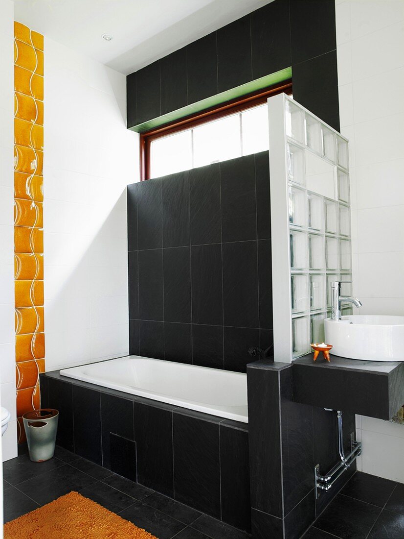 Badezimmer in Schwarz-weiß mit einer Trennwand aus Glasbausteinen