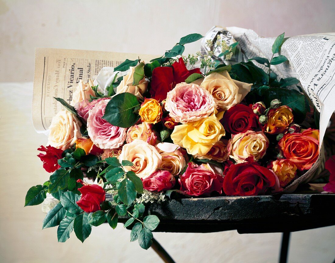 Red, yellow and pink roses on table