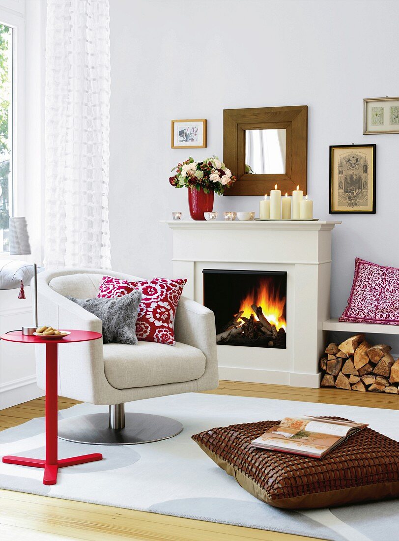 White living room with fireplace, swivel chair and scatter cushions