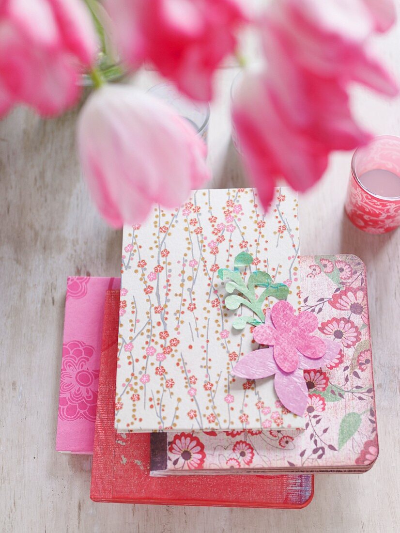 Several pink and red notebooks in floral covers