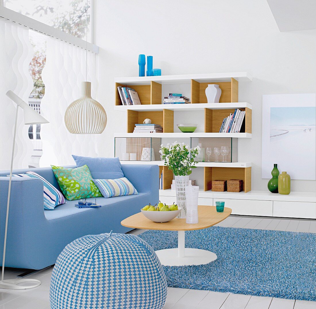 Blue sofa, shelving with glass compartments and blue and white beanbag