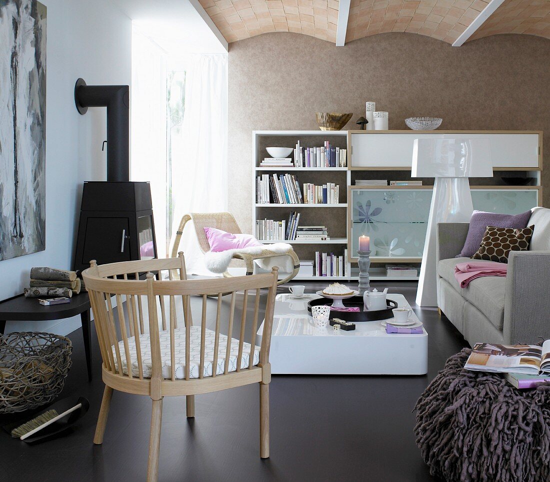 Wohnraum mit braunem Lederboden, Sofa, Couchtisch, Schrankwand, Kaminofen & Armlehnstuhl