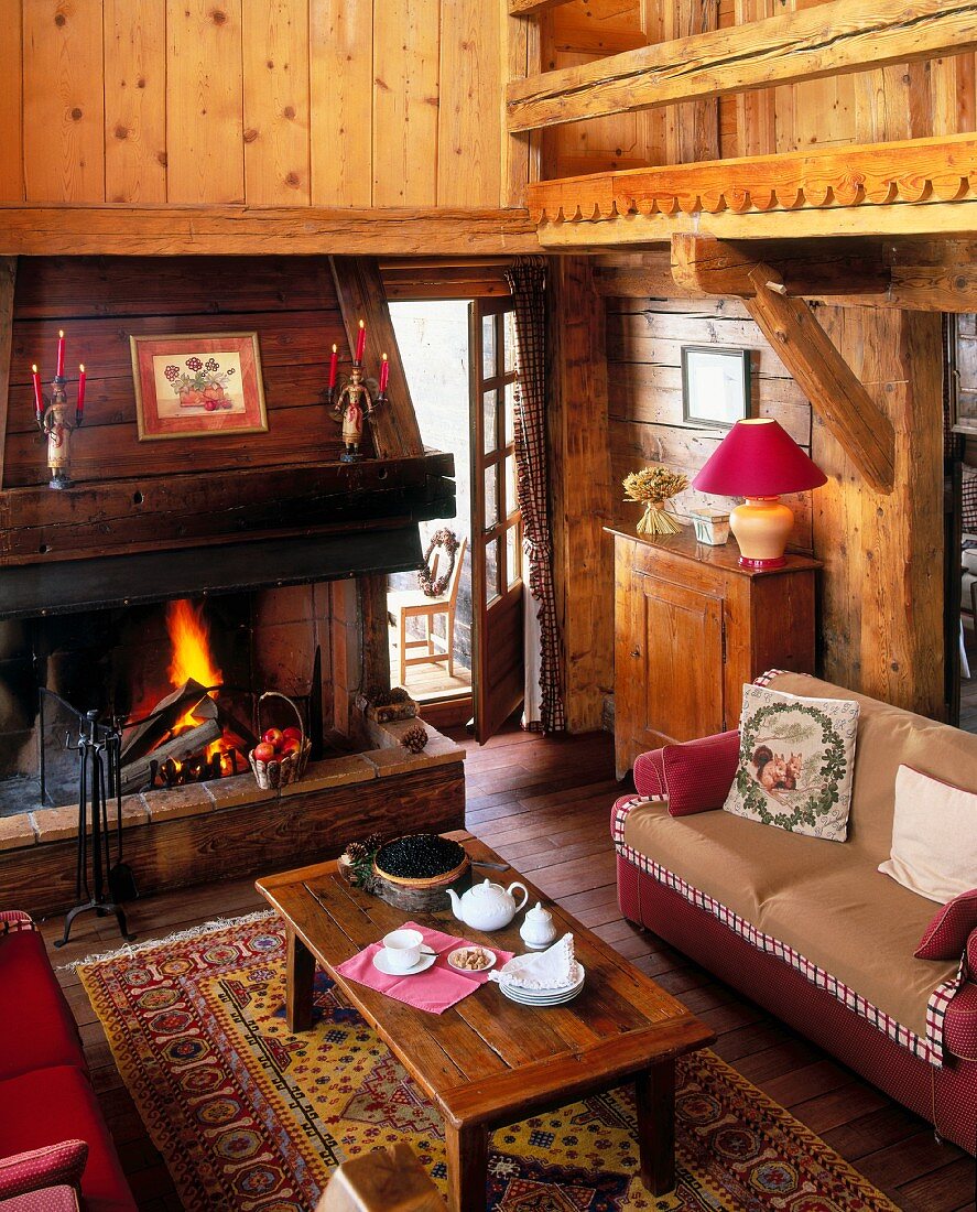 A rustic living area with an open fire in a chalet in the alps