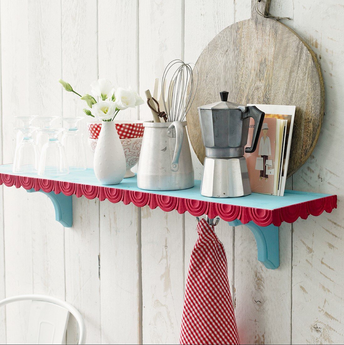 Kitchen utensils on blue shelf with red decorative trim