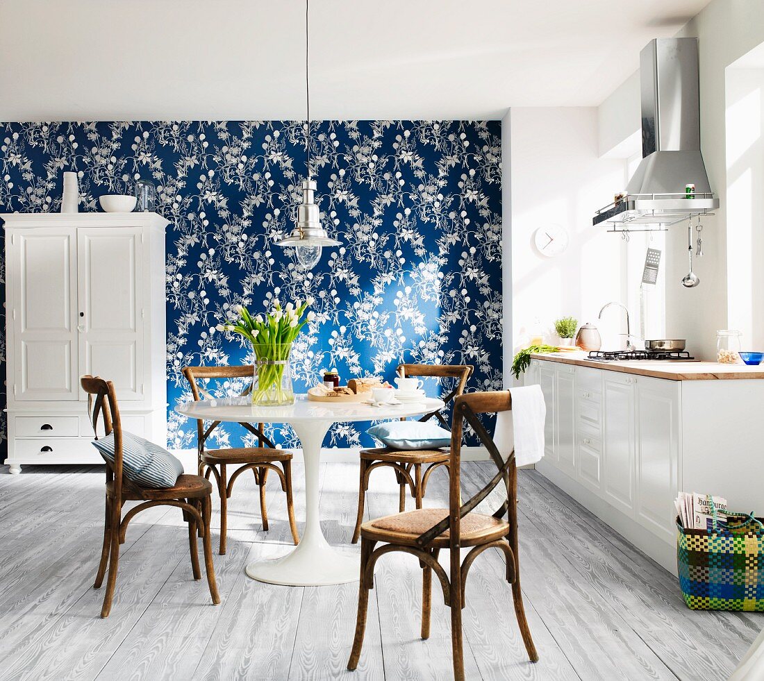 White, modern country house kitchen with blue and white wallpaper on one wall