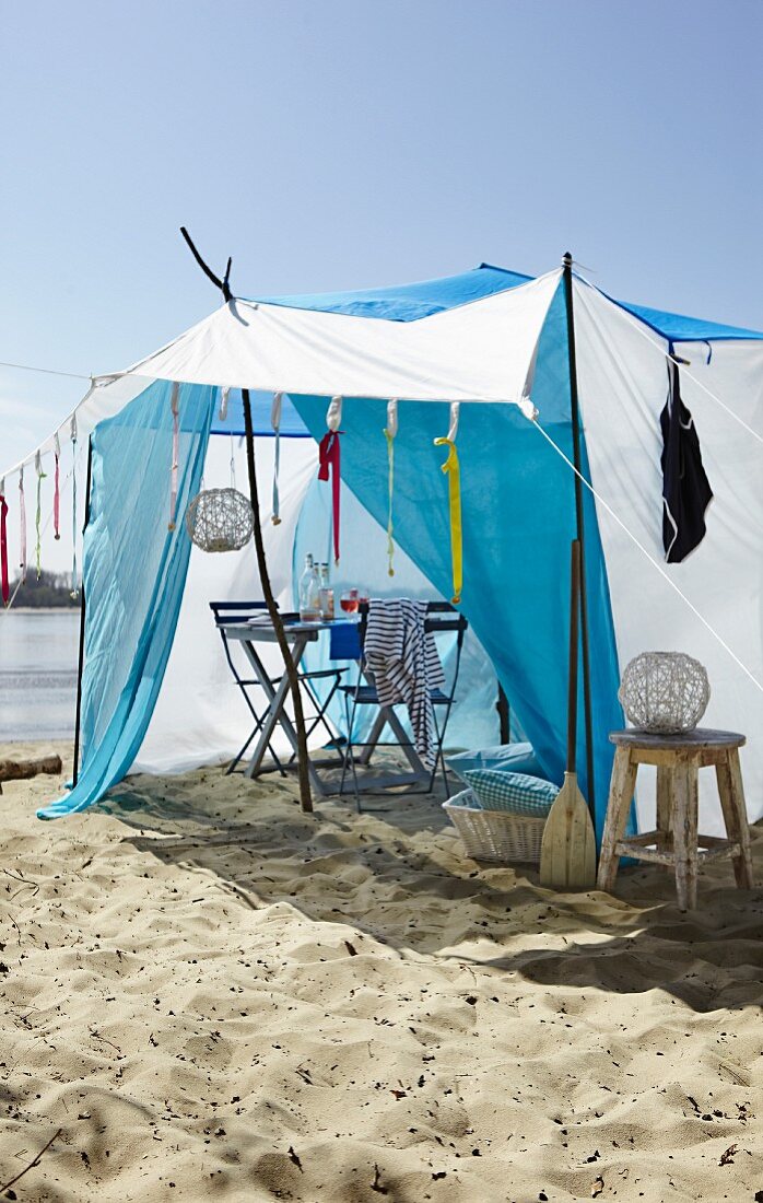 Tisch mit Stühlen im Zelt am Strand