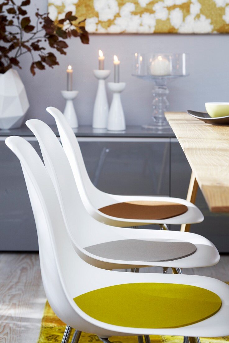 Plastic chairs with colourful seat cushions at dining table