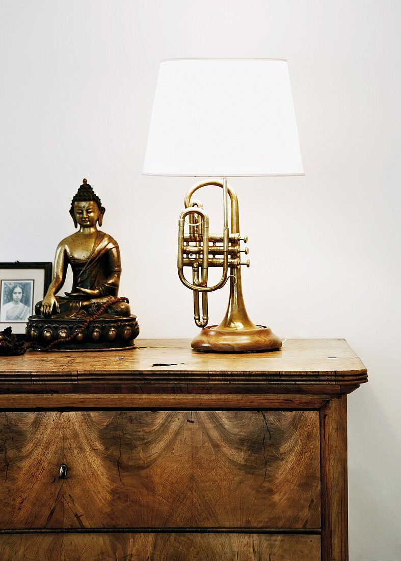 Lamp upcycled from old trumpet & Buddha figurine on chest of drawers