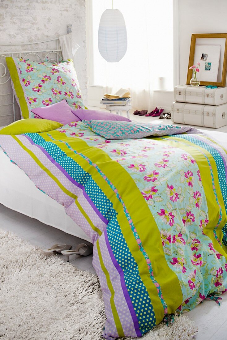Bed with colourful, reversible bed linen