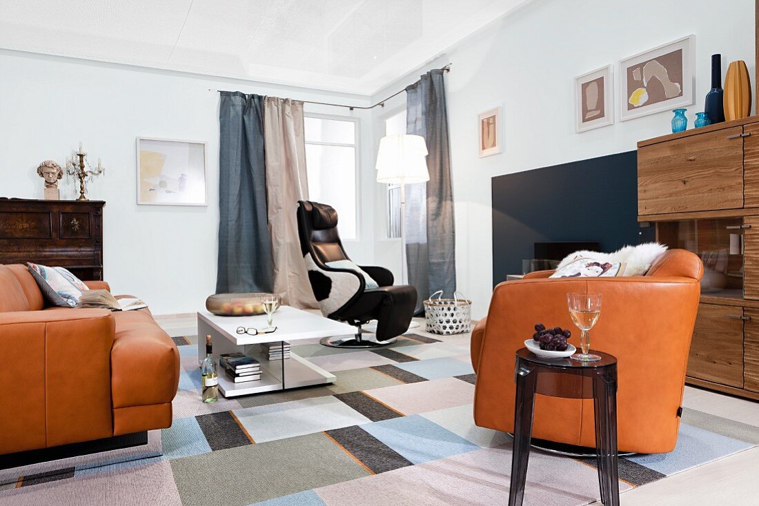 Wohnzimmer mit Ledergarnitur und Relax-Sessel im Kuhfelloptik