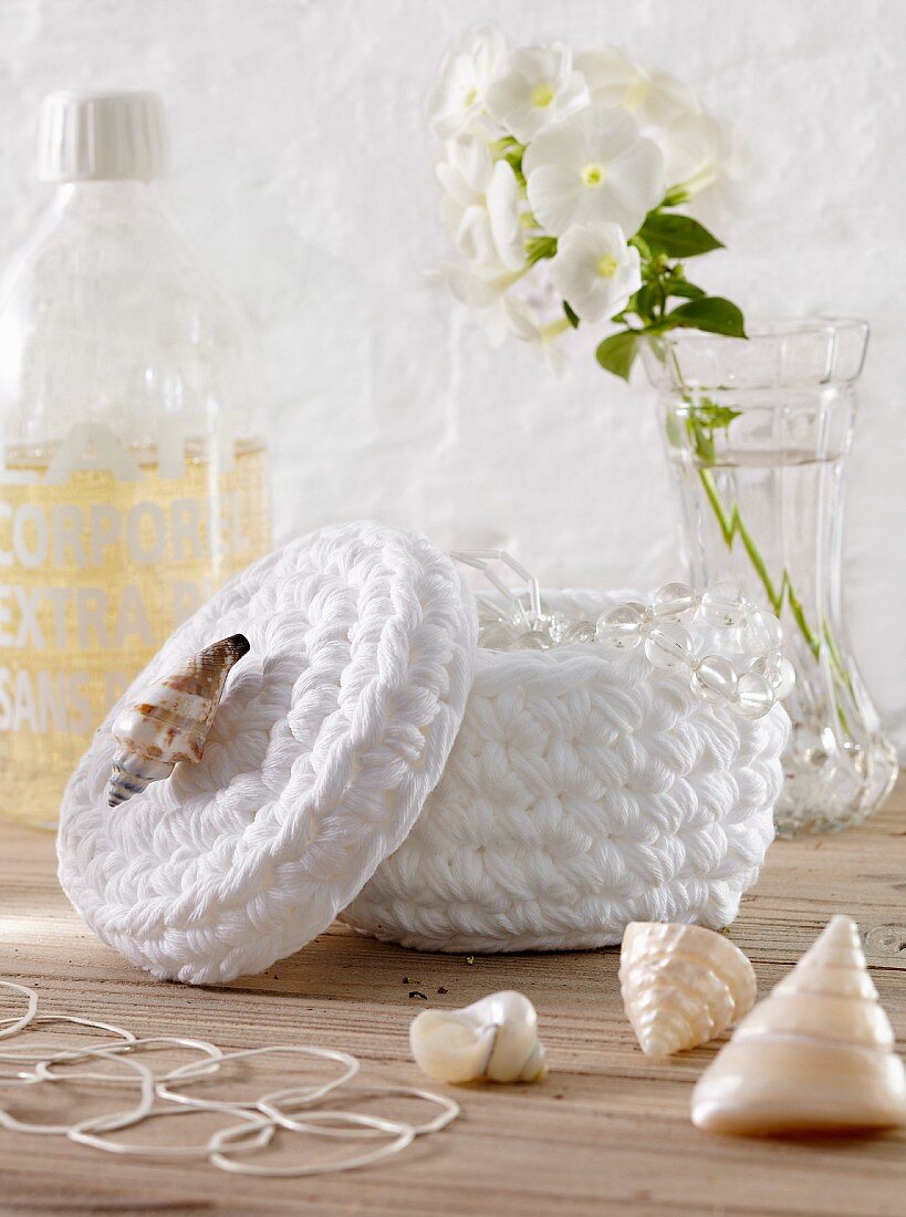 A white crocheted container with seashells
