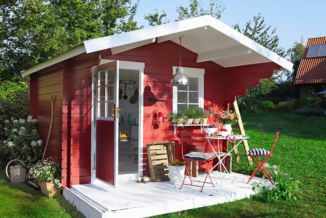 Rotes Gartenhaus aus Holz im skandinavischen Stil