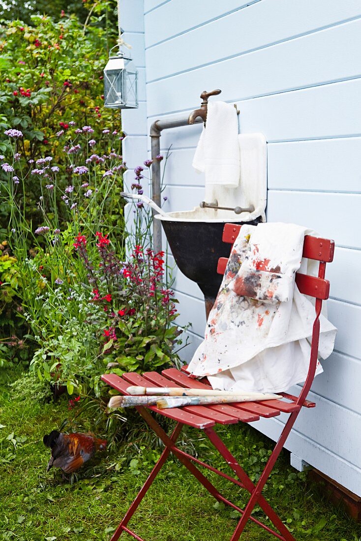 Outdoor sink & folding chair outside Scandinavian summer house