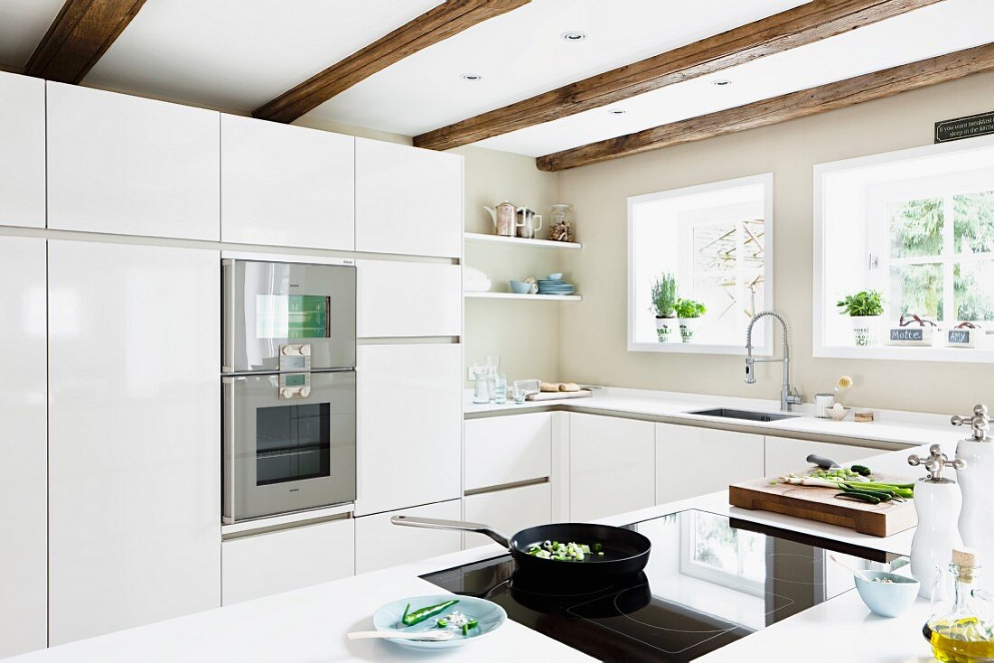 White fitted kitchen with glossy fronts