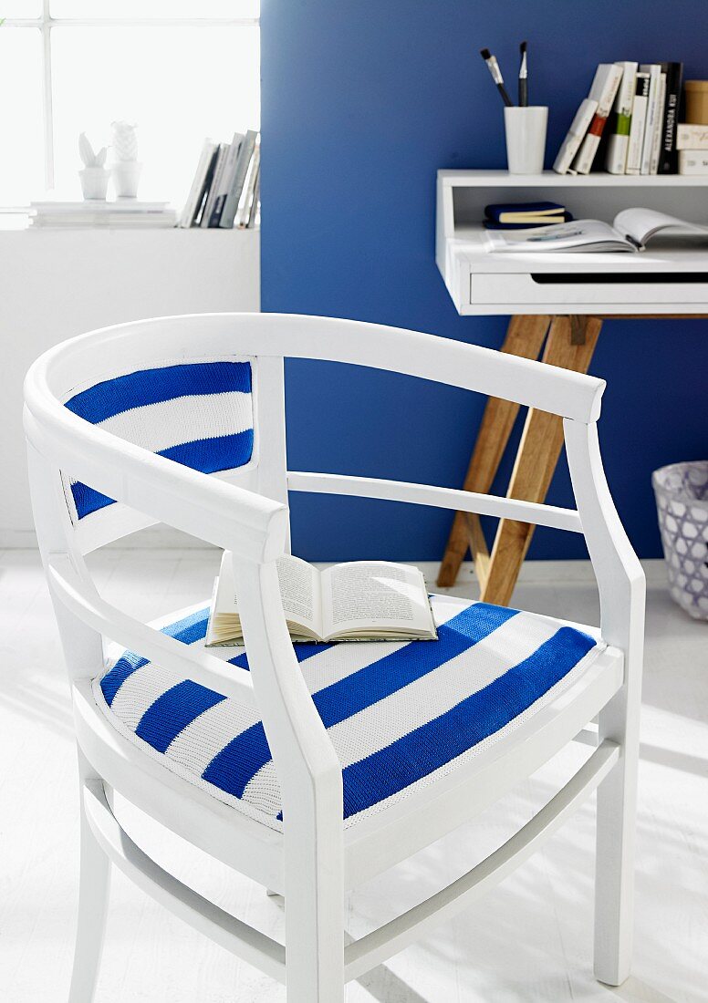 Weiß lackierter Holzstuhl mit blau-weiss gestreiftem Bezug