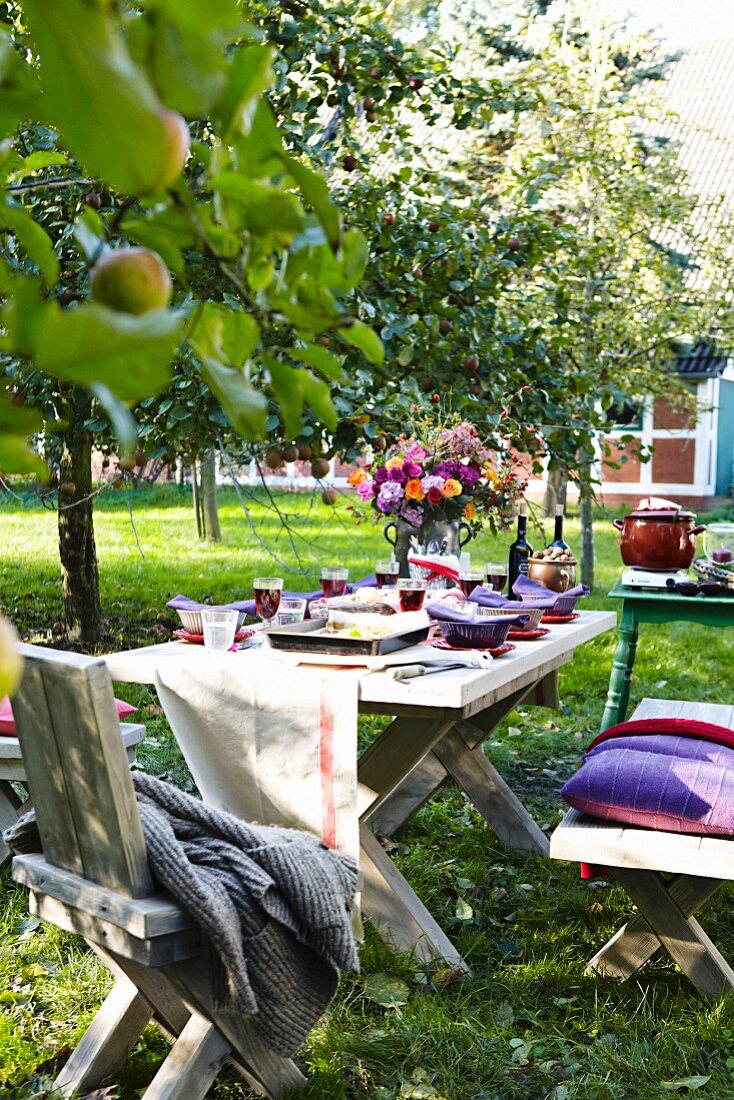 Gedeckter Tisch unter Apfelbaum im Garten