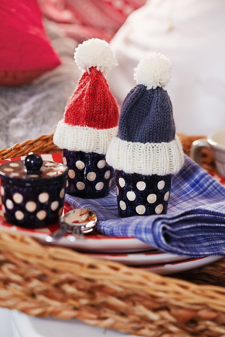 Knitted egg cosies shaped like bobble hats