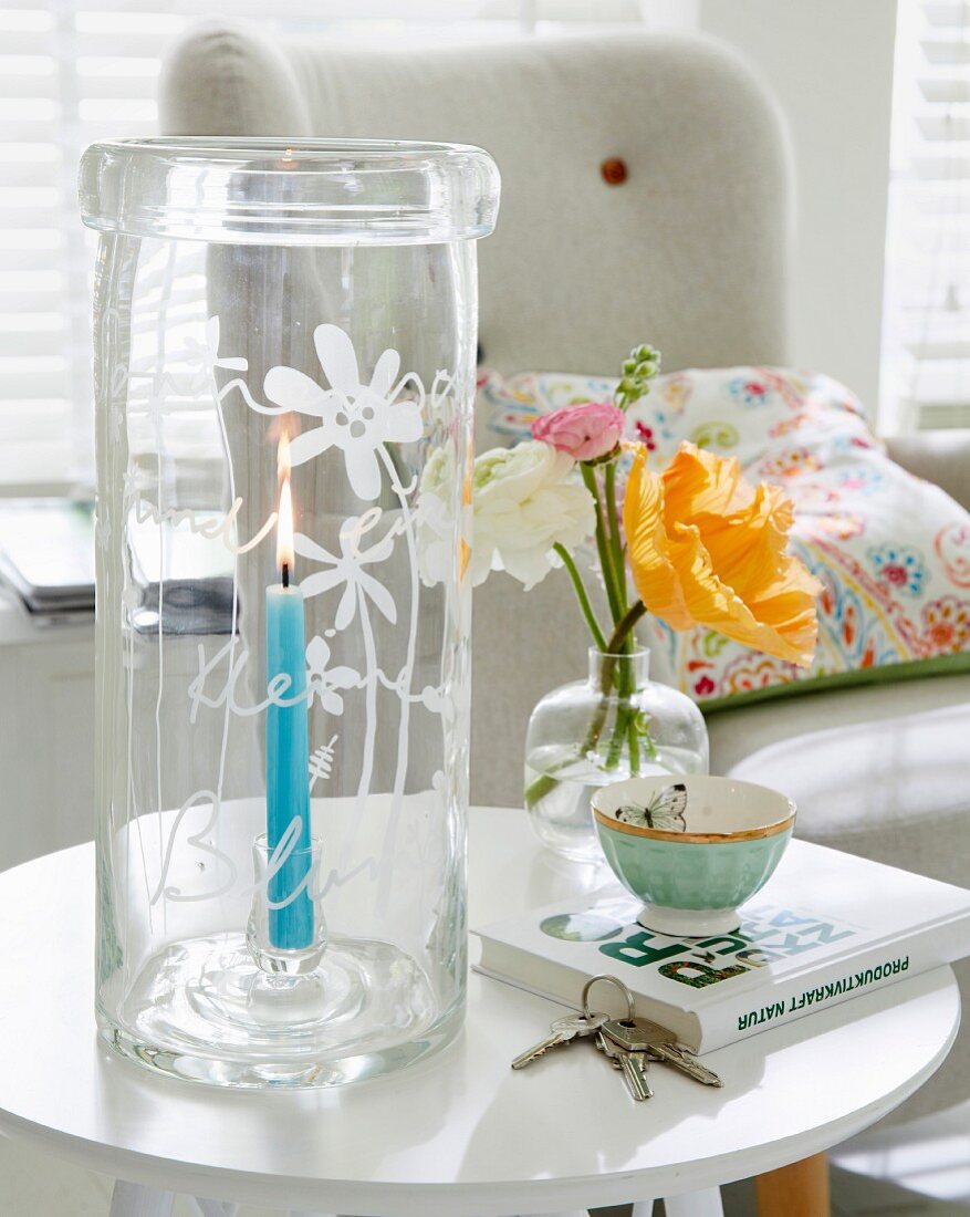 Hohes Windlicht aus Glas mit handgemachter Gravur auf Beistelltisch