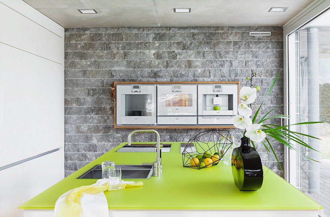 Küche mit Steinwänden & grüner Arbeitsplatte