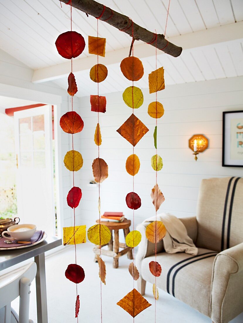 Wohnraum herbstlich dekoriert mit Mobile aus Herbstblättern