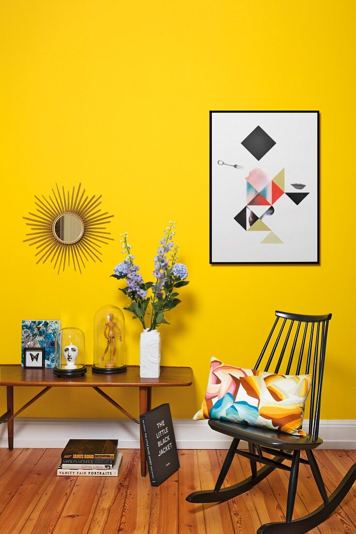 Gelber Wohnraum mit Tisch & Schaukelstuhl im Retrostil