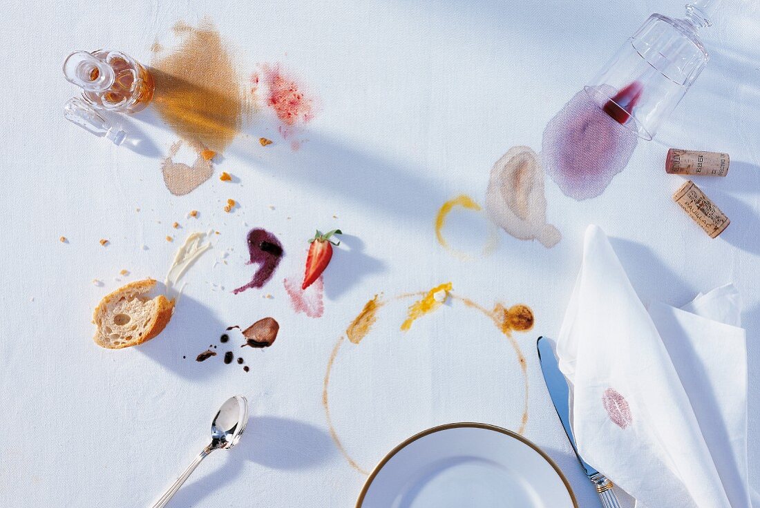 Overhead view of various stains and leftovers on white tablecloth