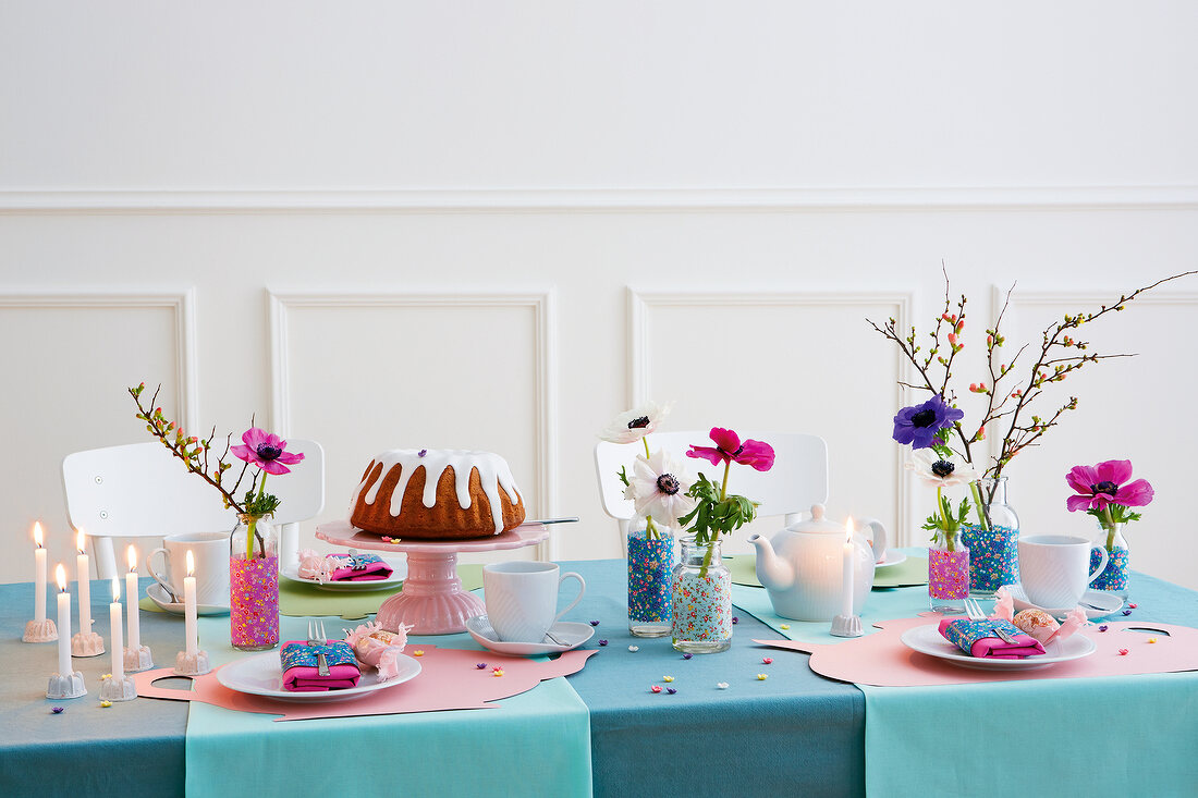 Gedeckter Geburtstagstisch mit Kuchen, Kerzen & Blumen in Dekovasen