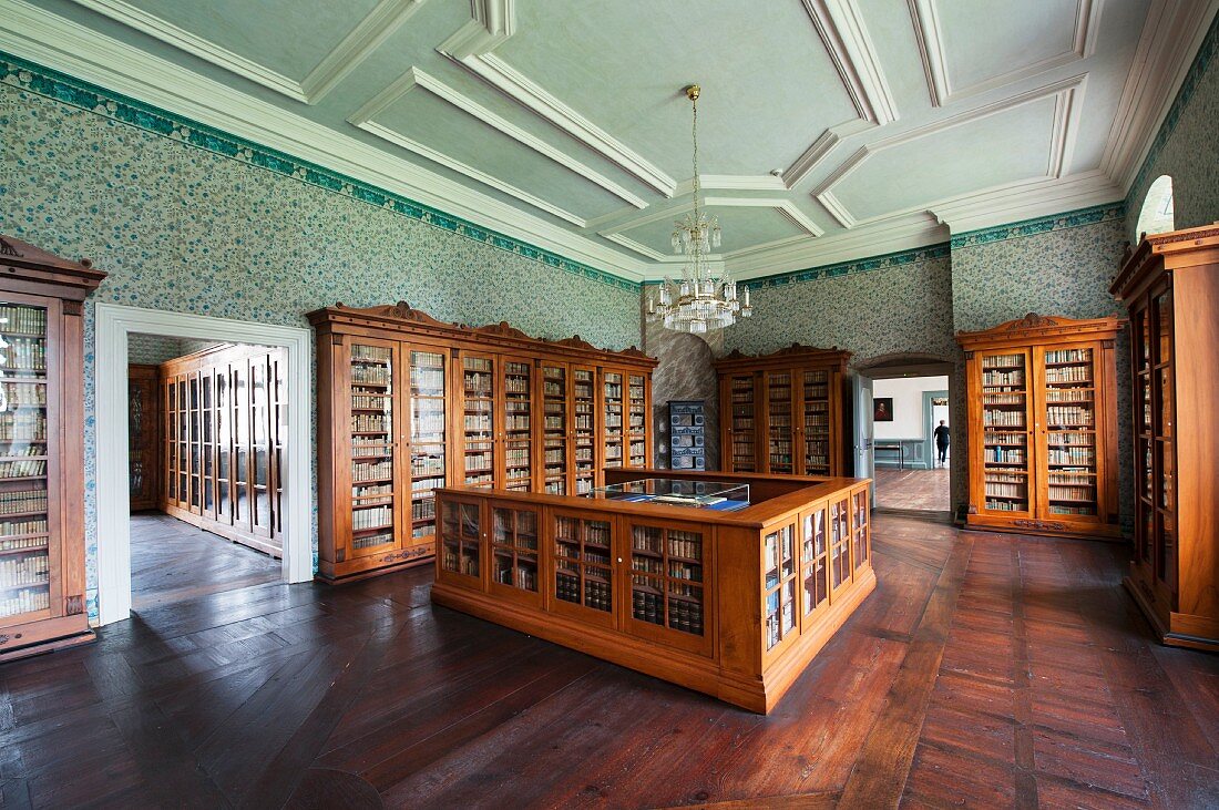 The library at Corvey – Biedermeier bookshelves and a counter in a room with a stucco ceiling