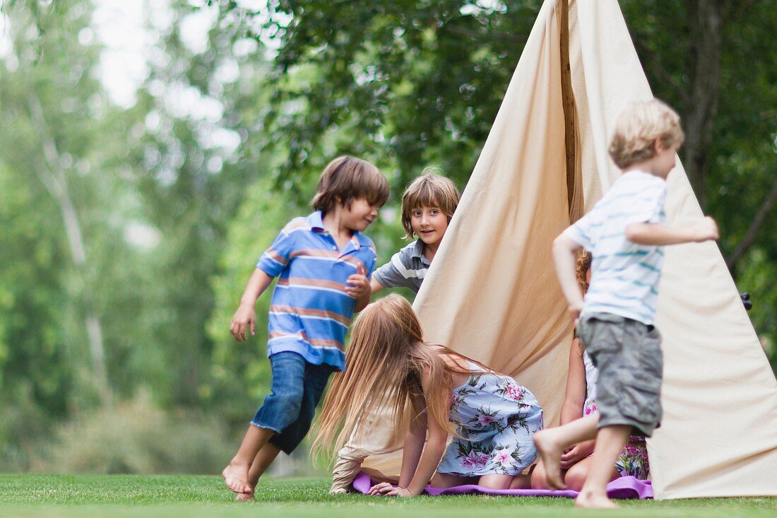 Kinder spielen bei einem Zelt im Garten