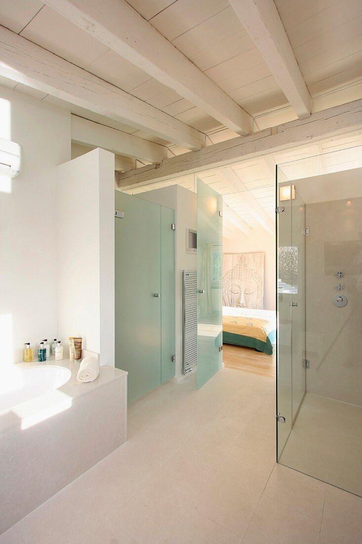 Modernes Bad mit Holzbalkendecke über verglastem Duschbereich und Blick in Schlafzimmer