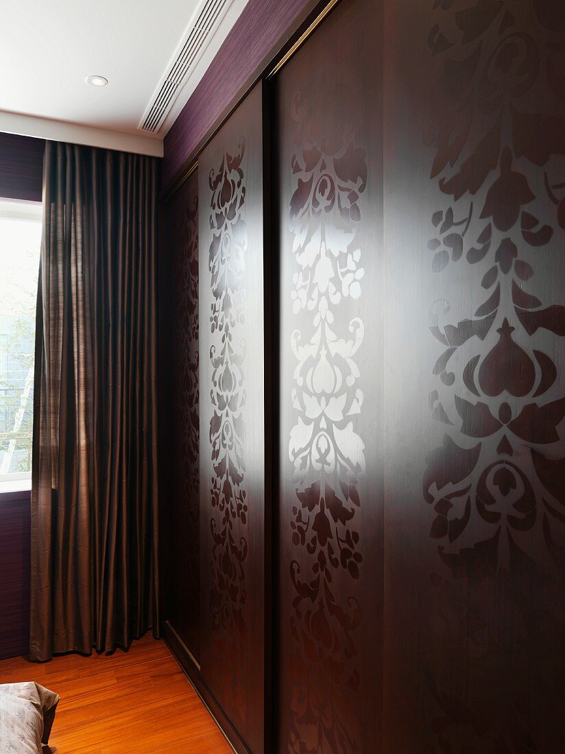 Fitted wardrobes with glossy floral patterns on matte sliding doors