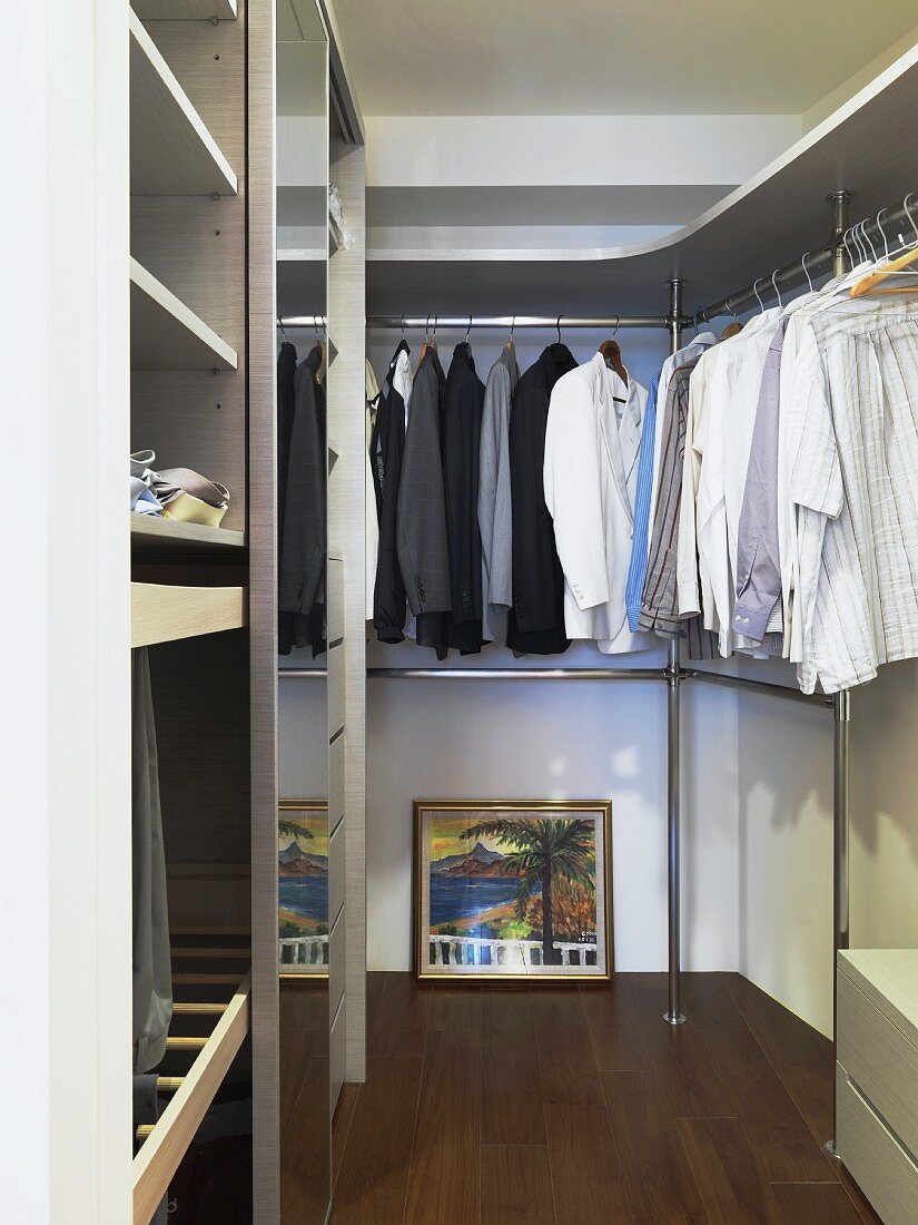 Gentlemen's clothes hanging up on rods in a modern dressing room