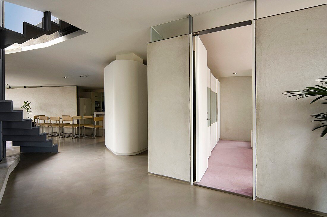 Zeitgenössischer Vorraum mit Treppe und Blick durch offene Tür auf rosa Teppich