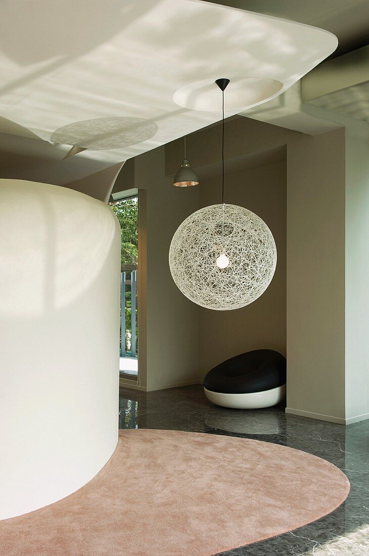 Minimalistischer Vorraum mit kugelförmiger Hängelampe aus Geflecht in zeitgenössischem Wohnraum