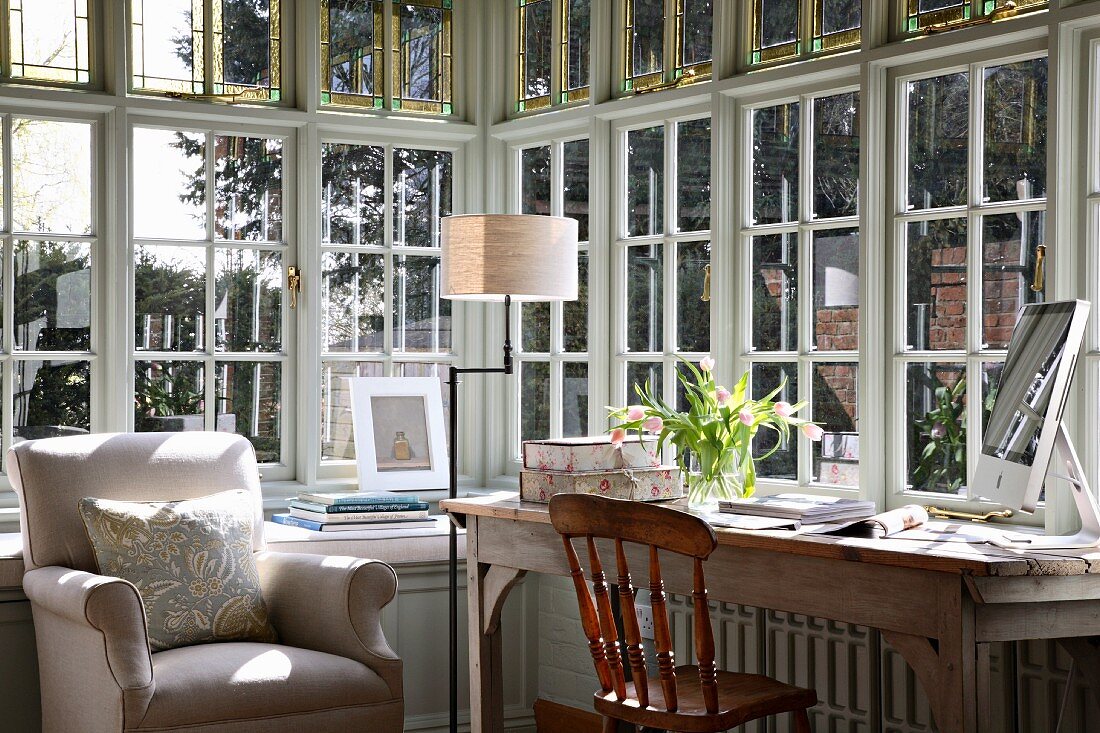 Bright workspace with traditional country-house furniture in bay of latticed windows