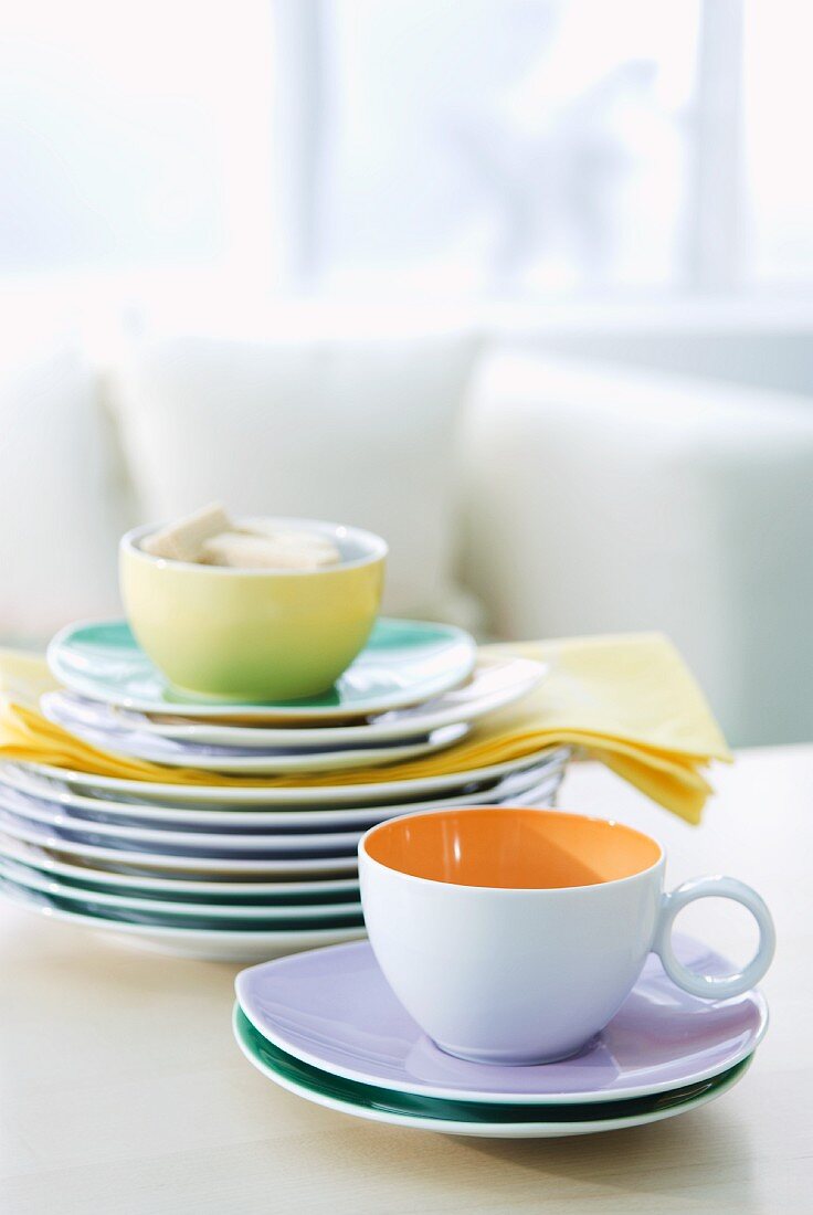 Teetassen und Tellerstapel auf einem Tisch