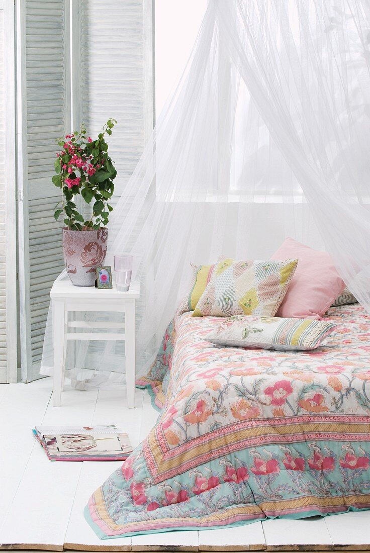 Tagesdecke mit Blumenmuster auf einem Bett mit Baldachin