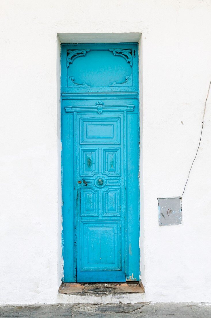 weiße Fassade mit strahlend blauer Eingangstür