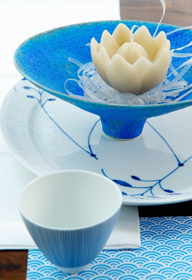 Kerze mit Lotosblütenmotiv auf blauer Schale und Porzellan mit weiss blauer Bemalung