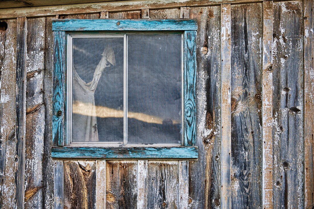 Verwitterte Holzhütte mit kleinem Fenster