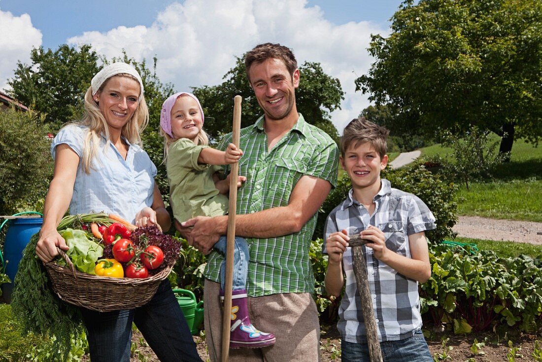 Familie mit zwei Kindern im Gemüsegarten