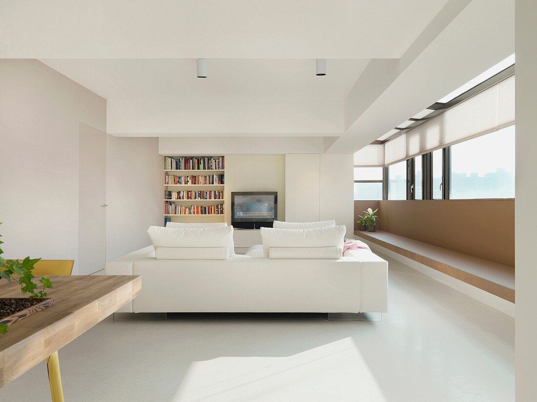 Weisses Sofa in minimalistischem Wohnzimmer mit verglastem Erker