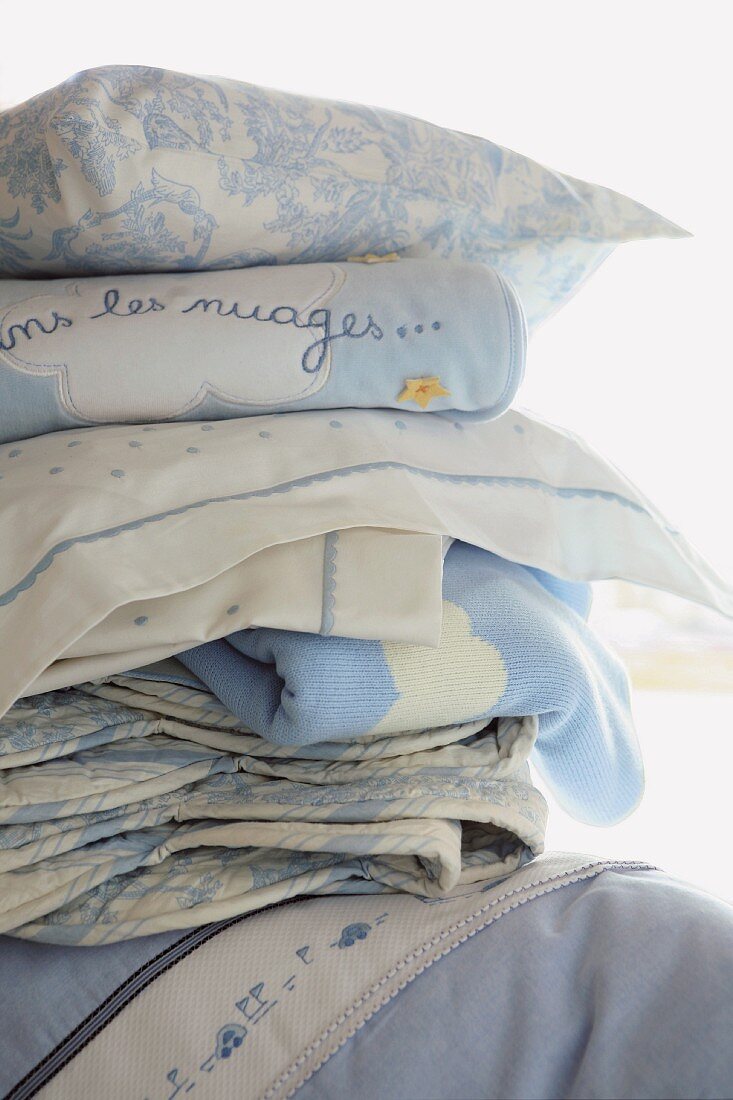 Stack of blue and white blankets and cushions