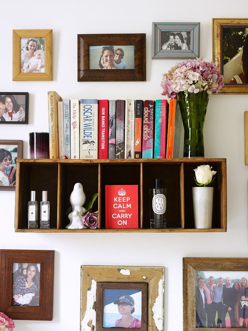 Kleines Bücherregal von eingerahmten Fotos umgeben