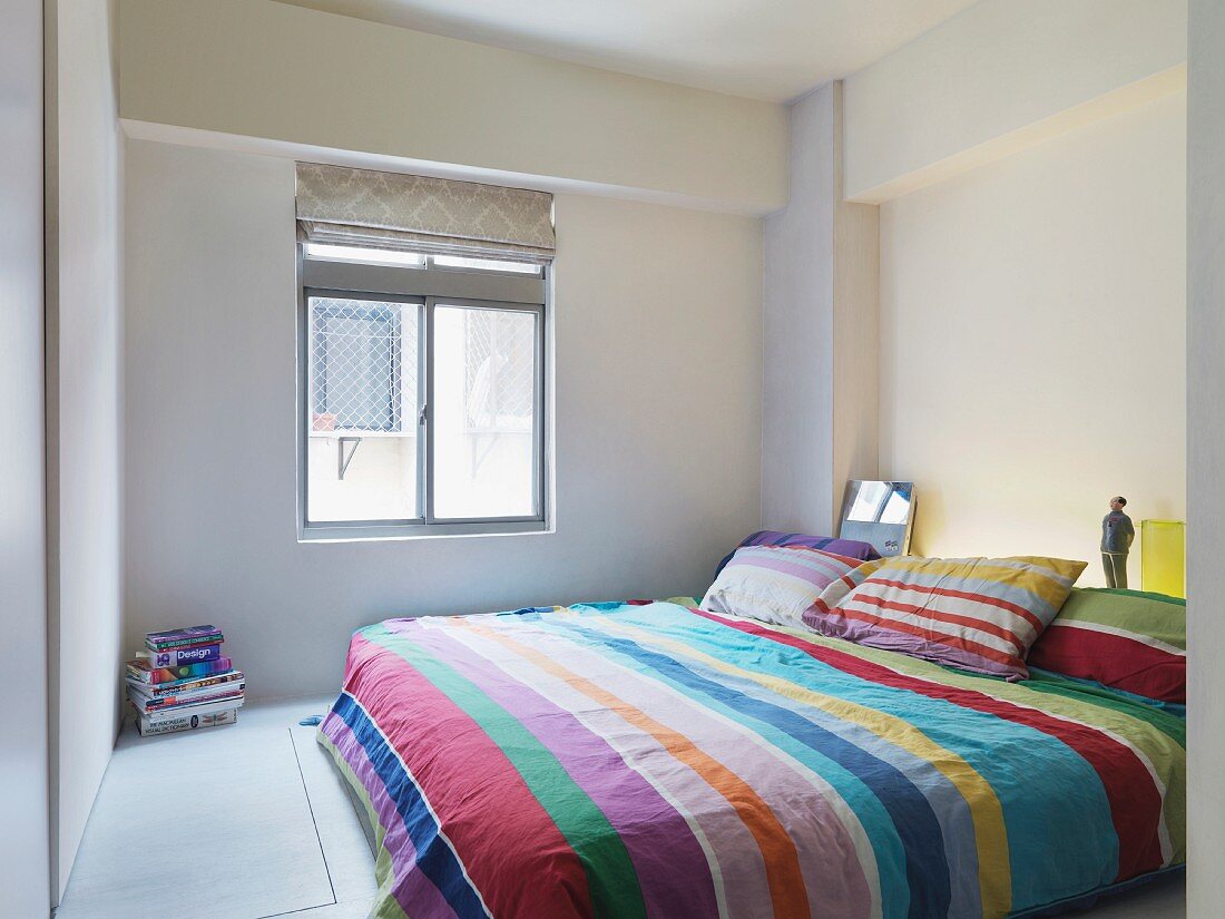 Bettwäsche mit Streifenmuster auf Doppelbett in minimalistischen Schlafzimmer